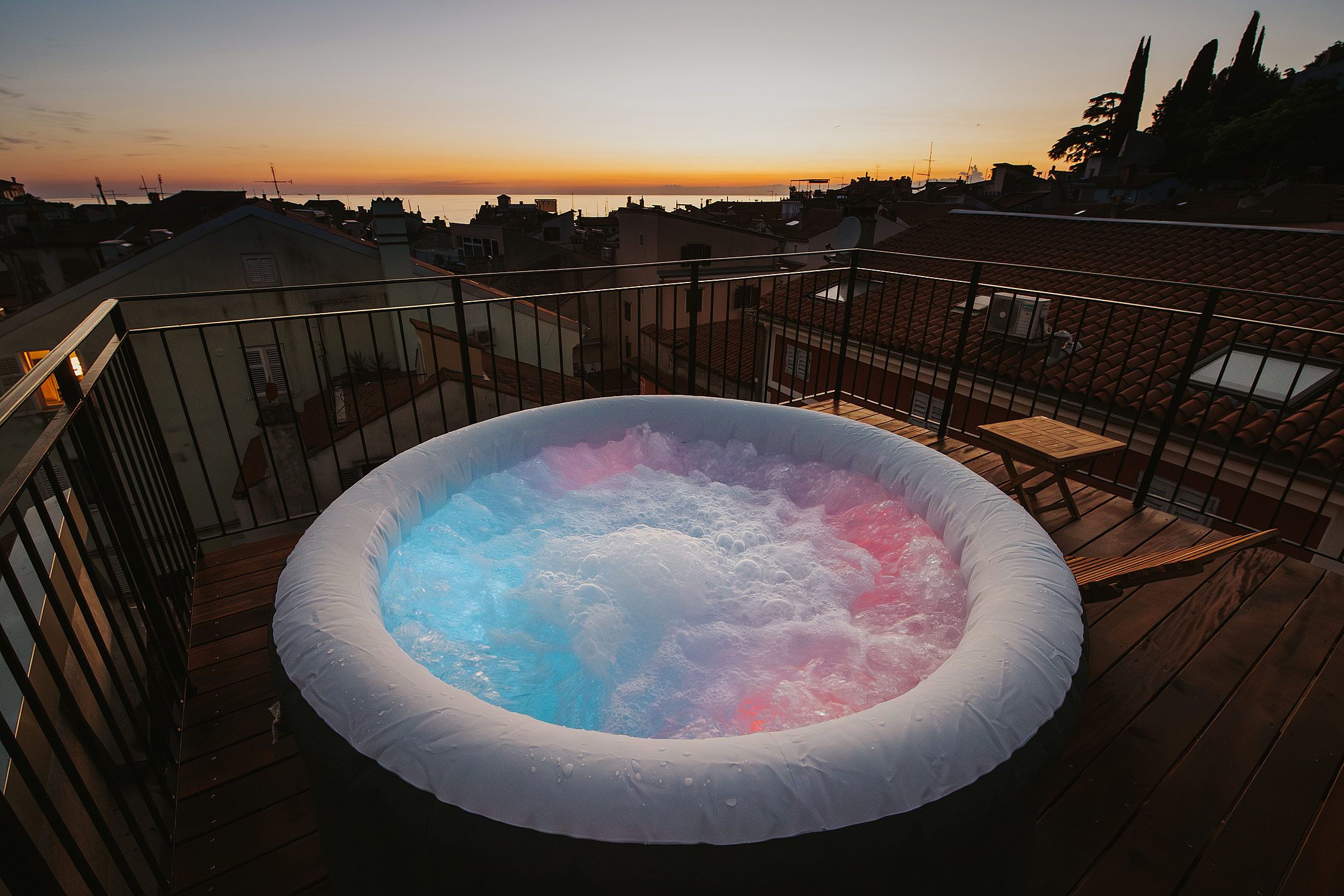 Zunanji jacuzzi na terasi ob barvitem sončnem zahodu
